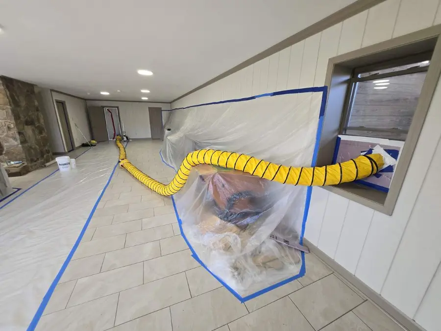 Taped plastic containment, floor protection and ducted air filtration in a finished basement during mold remediation