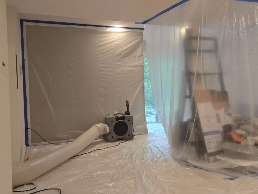 Plastic containment and an air scrubber set up inside a home during mold remediation